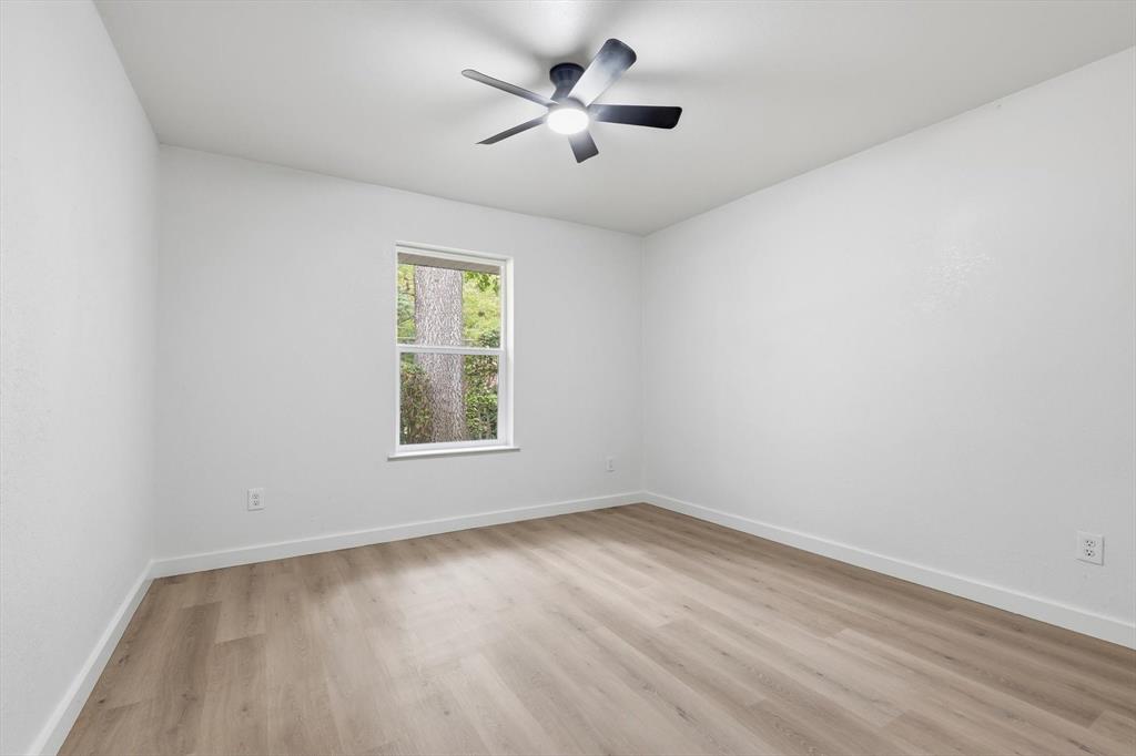 5940 Hunters View Lane Dallas, TX 75232 - Photo 14 of 24 Empty room with light wood-style flooring and ceiling fan