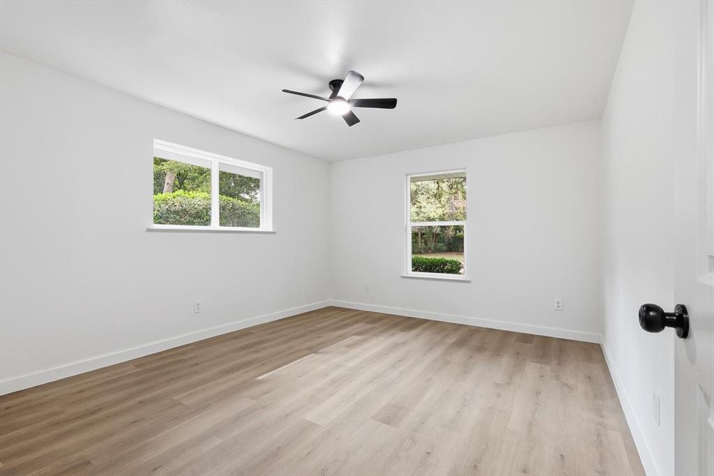 5940 Hunters View Lane Dallas, TX 75232 - Photo 16 of 24 Unfurnished room with light wood-type flooring and ceiling fan