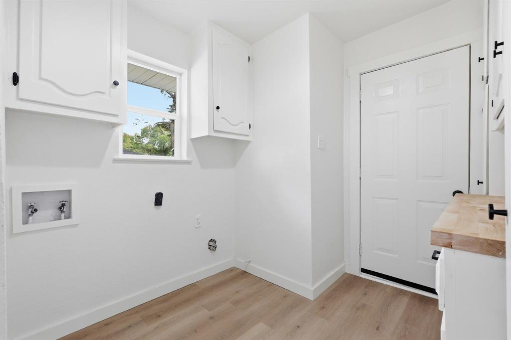 5940 Hunters View Lane Dallas, TX 75232 - Photo 6 of 24 Laundry room featuring cabinet space, light wood-type flooring, and hookup for a washing machine
