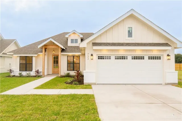 a view of a house with a yard and garage