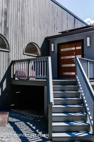 a view of staircase with lots of frames on wall and windows