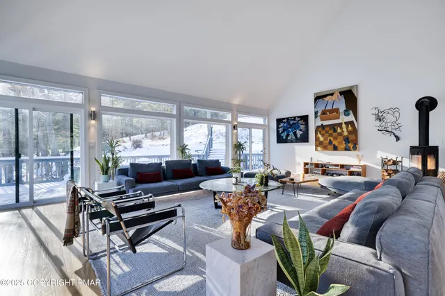 a living room with furniture large window and a flat screen tv
