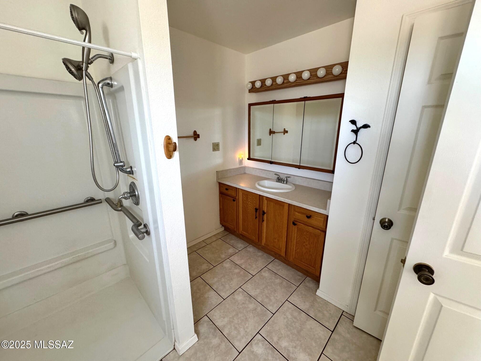 13384 South Cottonwood Road Pearce, AZ 85625 - Photo 19 of 46 a bathroom with a granite countertop sink a mirror and shower