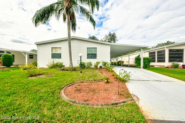 a view of a house with a yard and potted plants