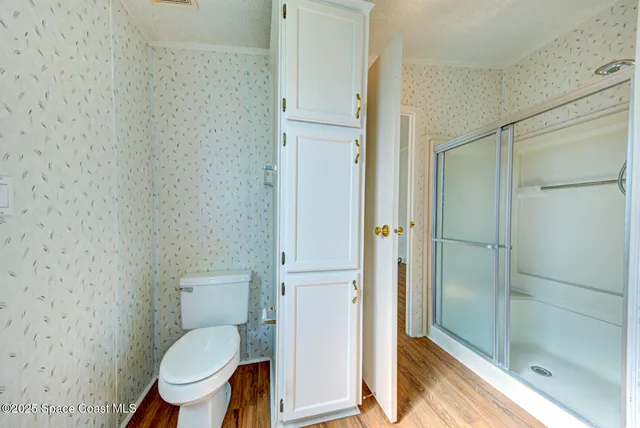 a bathroom with a granite countertop toilet a sink and a glass door