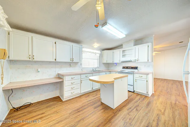 a kitchen with a sink dishwasher white cabinets with a dining table and chairs