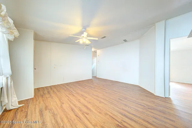 a view of empty room with wooden floor