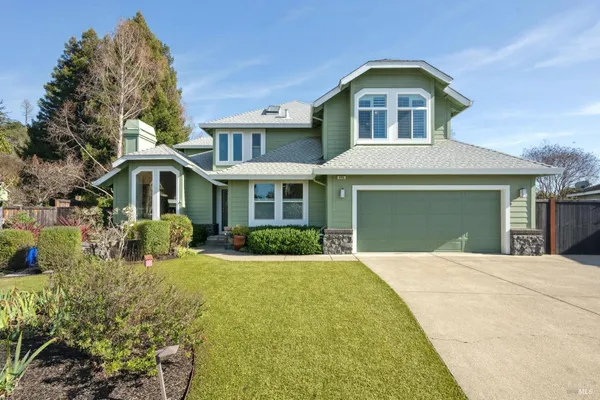 a front view of a house with yard and green space
