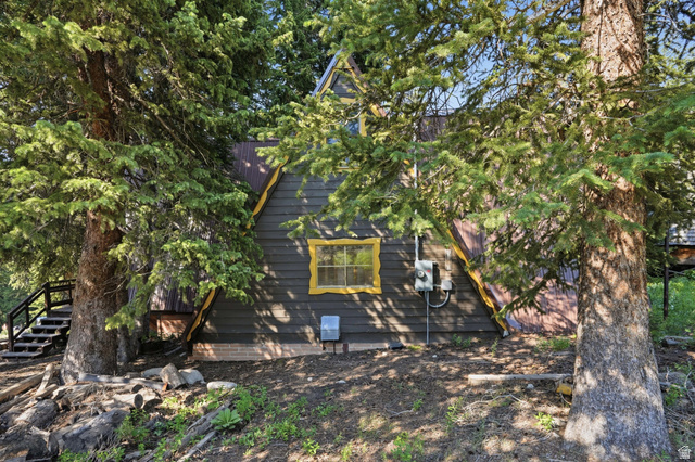 8505 South Snake Crk Road Salt Lake City, UT 84121 - Photo 43 of 67 A-frame style residence featuring dark siding, a corrugated metal roof, and bright yellow trim detailing