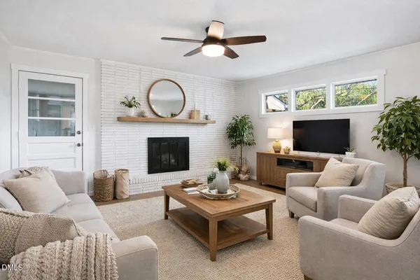 a living room with furniture a fireplace and a flat screen tv