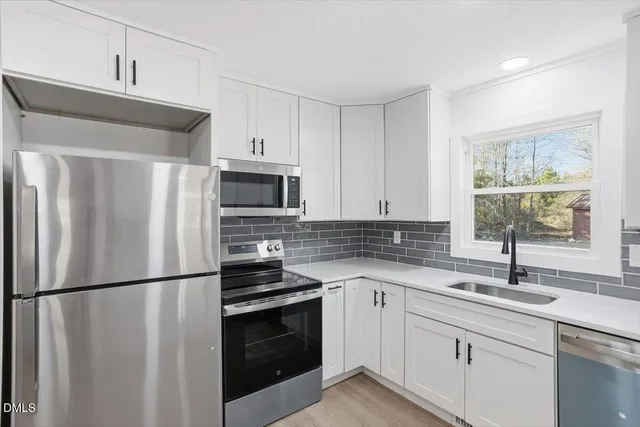 a kitchen with stainless steel appliances a refrigerator sink and cabinets