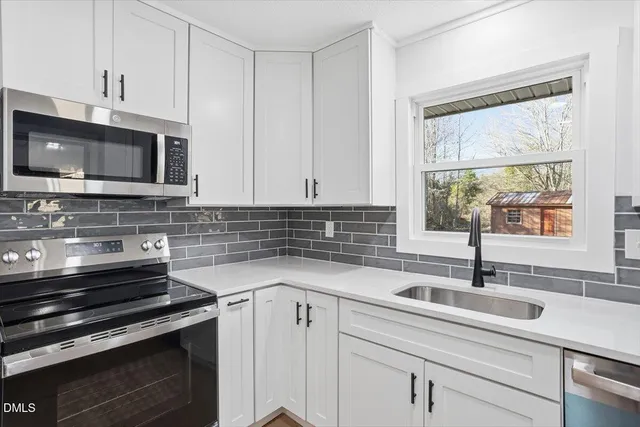 a kitchen with stainless steel appliances a sink a stove a microwave and cabinets