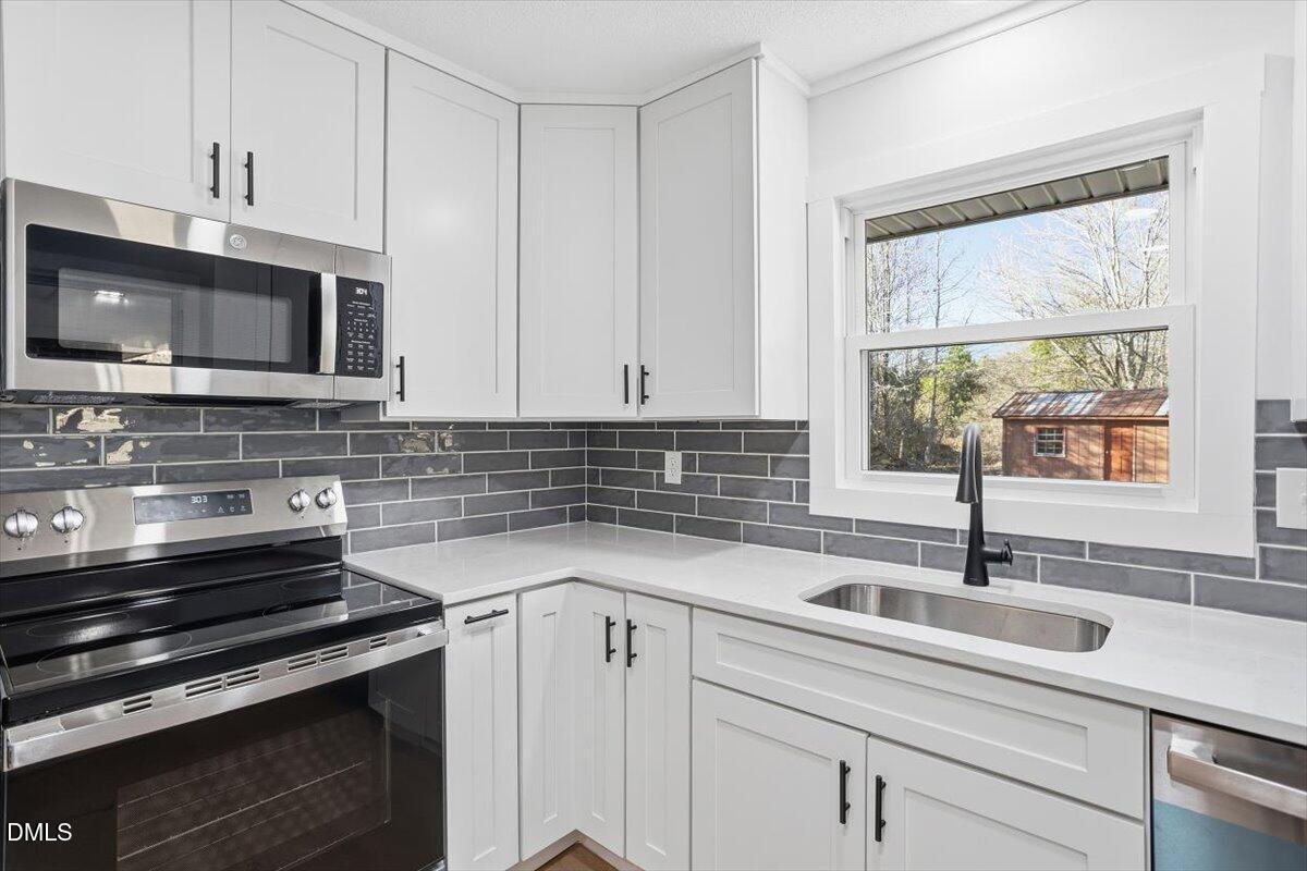 2609 Old Rte 22 Kenly, NC 27542 - Photo 21 of 43 a kitchen with stainless steel appliances a sink a stove a microwave and cabinets