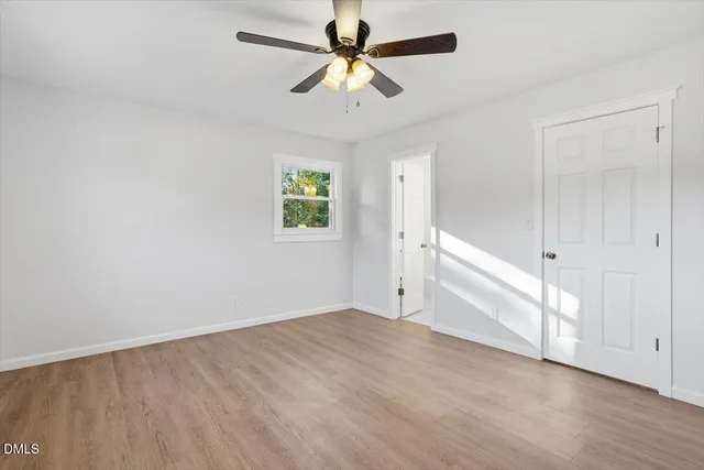 an empty room with fan and windows