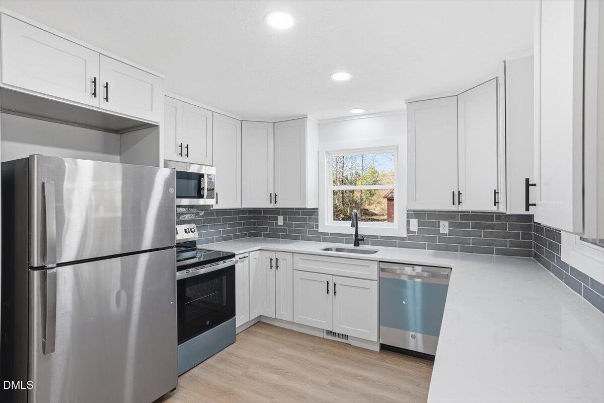 2609 Old Rte 22 Kenly, NC 27542 - Photo 8 of 43 a kitchen with a sink a refrigerator and white cabinets