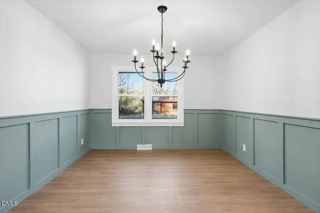 a kitchen with a sink a refrigerator and white cabinets
