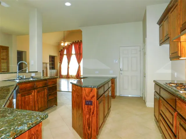 a kitchen filled with stainless steel appliances granite countertop a stove a sink and a refrigerator