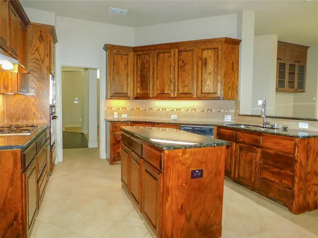 a utility room with stainless steel appliances granite countertop a stove and a sink
