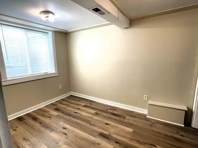 a view of a room with wooden floor and natural light