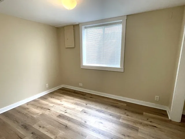 an empty room with wooden floor and a window