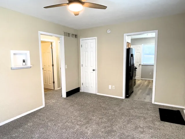 a view of an empty room with closet and a window