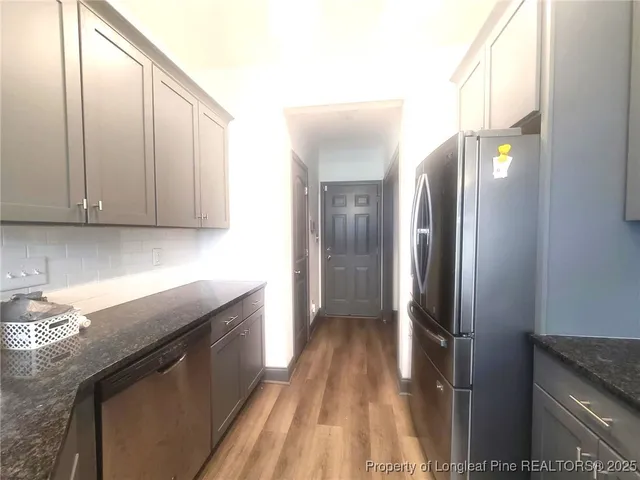 a kitchen with stainless steel appliances granite countertop a refrigerator and a sink