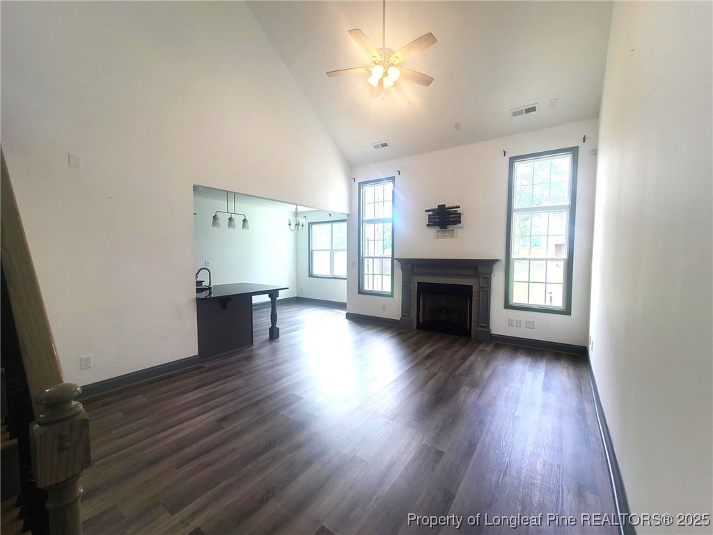 519 Hammond Farms Road Hope Mills, NC 28348 - Photo 5 of 34 an empty room with wooden floor fireplace and windows