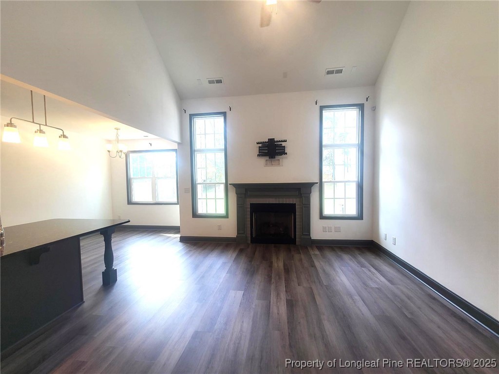 519 Hammond Farms Road Hope Mills, NC 28348 - Photo 6 of 34 an empty room with wooden floor fireplace and windows