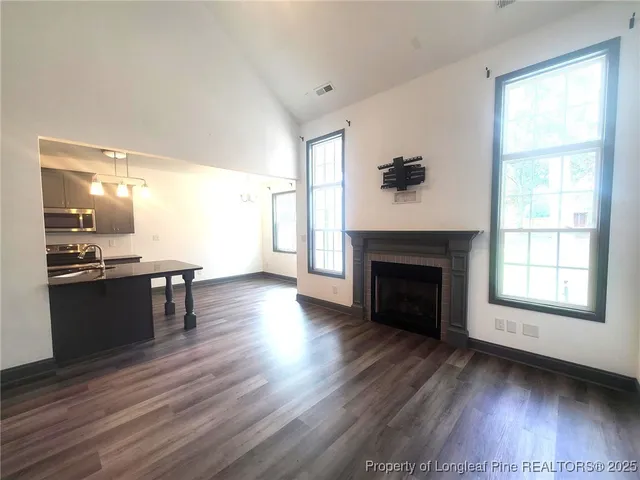 a living room with a fireplace and wooden floor