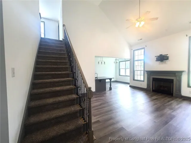 a view of a room with wooden floor fireplace and windows