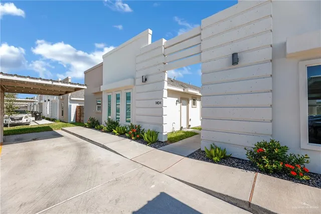 a view of a house with a yard and potted plants