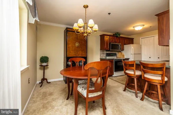 a room with stainless steel appliances kitchen island granite countertop furniture and a refrigerator