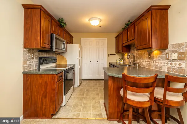 a kitchen with stainless steel appliances granite countertop a refrigerator stove and microwave