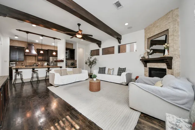 a living room with fireplace furniture and a kitchen view