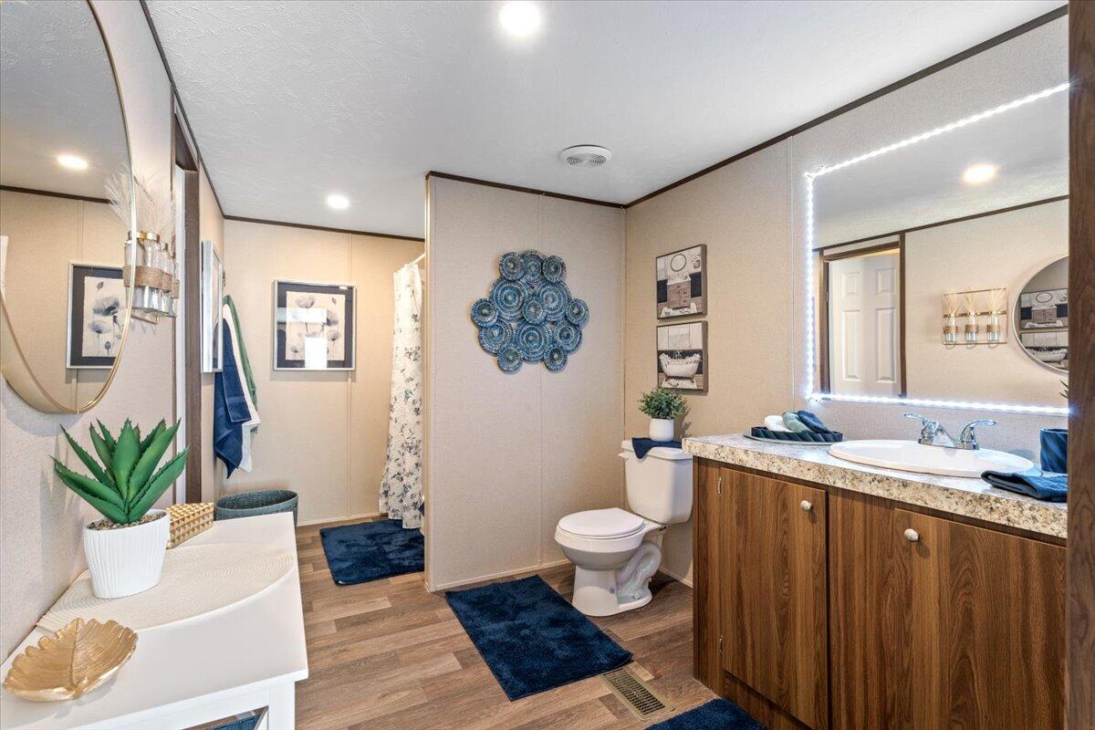 516 Sage Road Tahoka, TX 79373 - Photo 12 of 30 a bath room with a toilet a sink and a mirror