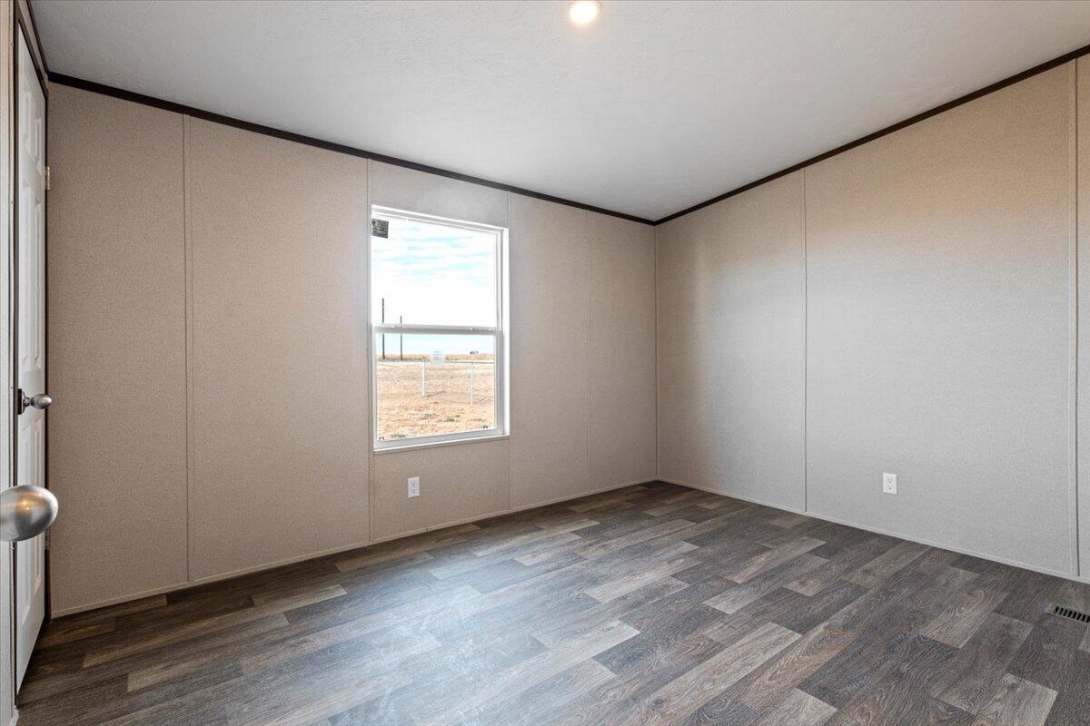 516 Sage Road Tahoka, TX 79373 - Photo 15 of 30 an empty room with wooden floor and windows