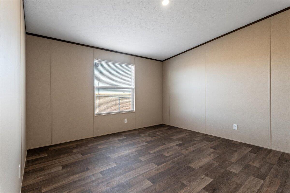 516 Sage Road Tahoka, TX 79373 - Photo 17 of 30 an empty room with wooden floor and windows