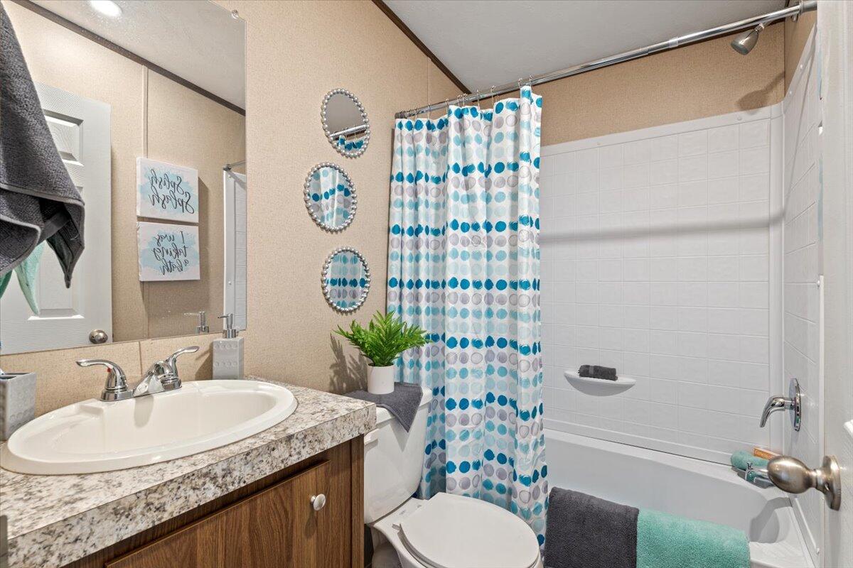 516 Sage Road Tahoka, TX 79373 - Photo 19 of 30 a bathroom with a granite countertop toilet sink and shower
