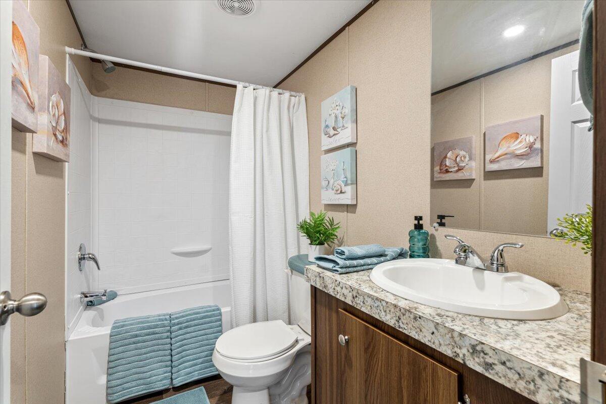 516 Sage Road Tahoka, TX 79373 - Photo 23 of 30 a bathroom with a granite countertop sink toilet and a mirror