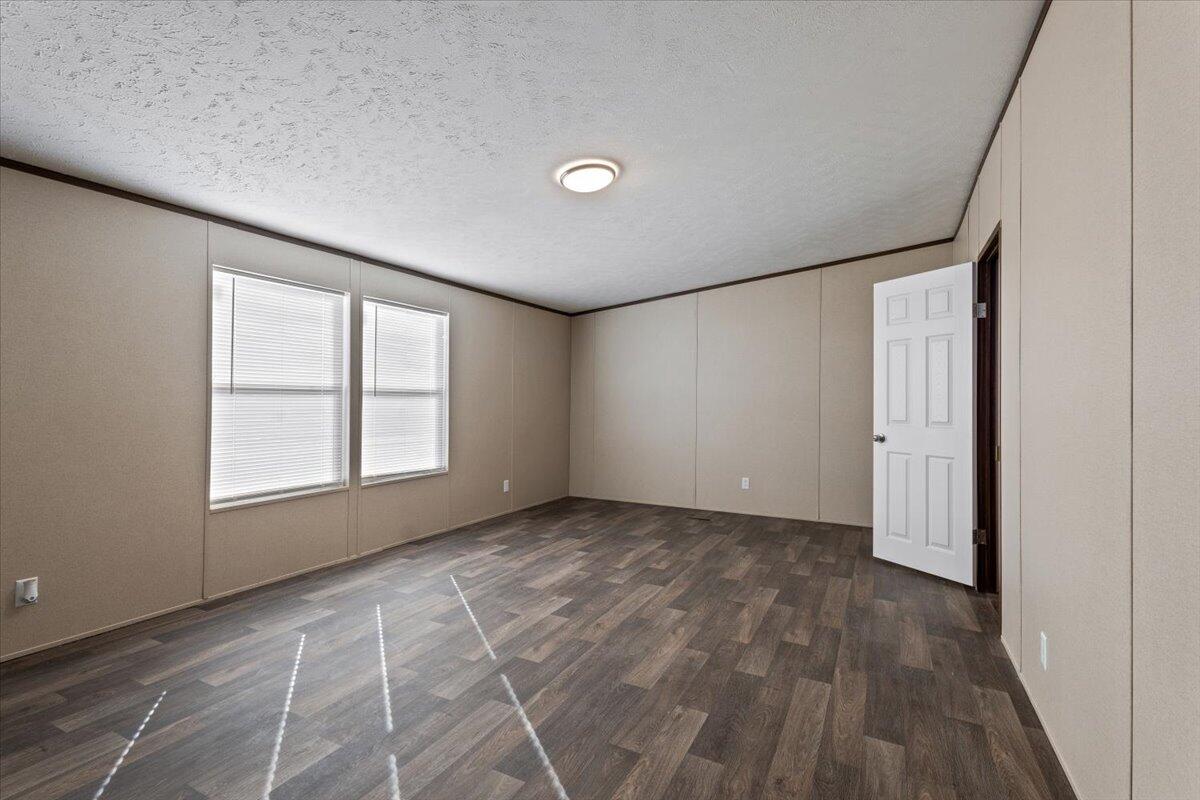 516 Sage Road Tahoka, TX 79373 - Photo 10 of 30 an empty room with wooden floor and windows