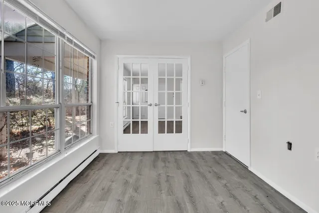 a view of empty room with wooden floor