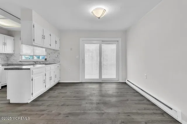 a view of a kitchen with wooden floor and electronic appliances