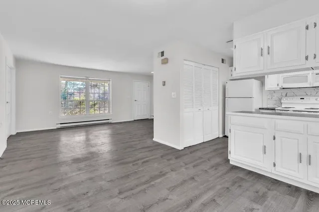 a kitchen with white cabinets and white appliances