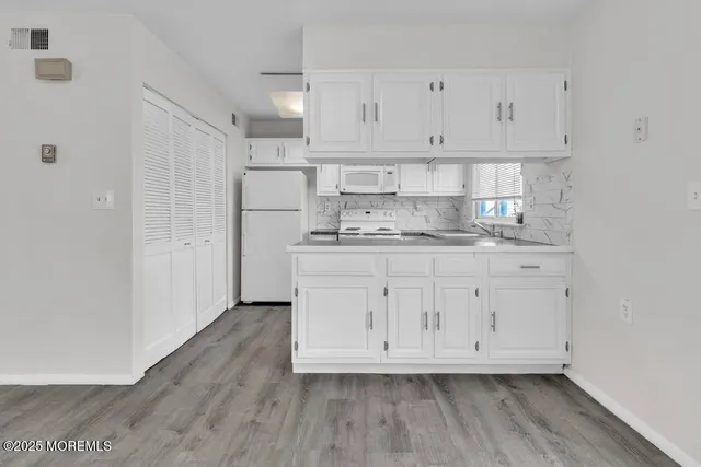 a kitchen with cabinets appliances a sink and a counter top space