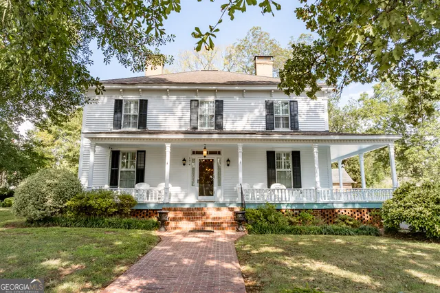 a front view of a house with a yard and potted plants