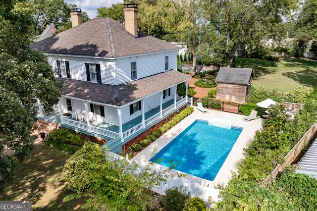 a view of an empty room with wooden floor and a chandelier