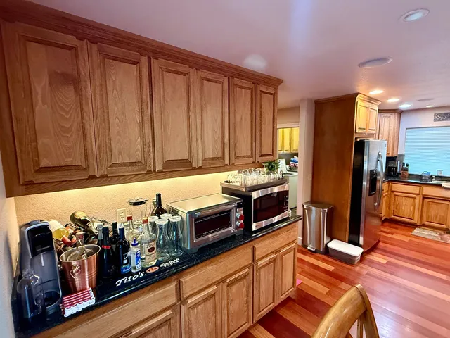 a kitchen with stainless steel appliances granite countertop a refrigerator and a stove top oven