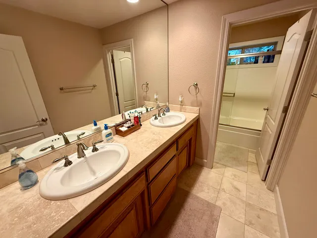 a bathroom with a double vanity sink and a mirror