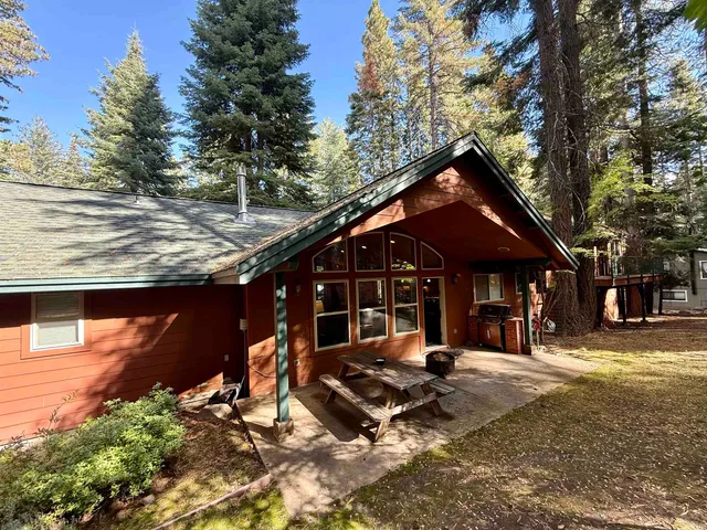 a front view of house with yard and trees around