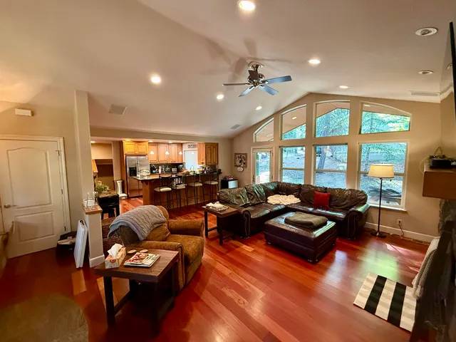 a living room with furniture floor to ceiling window and wooden floor